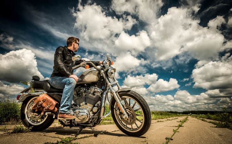 Mężczyzna z odchyloną głową siedzący na motocyklu
