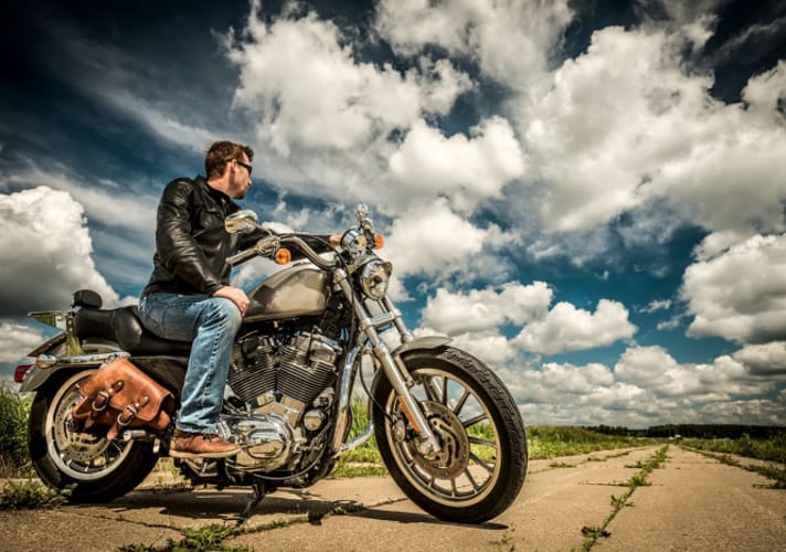 Mężczyzna z odchyloną głową siedzący na motocyklu