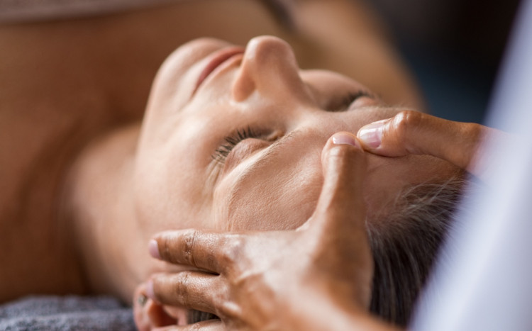 zrelaksowana kobieta na masażu twarzy