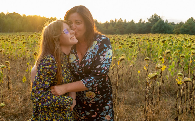 matka z córką przytulają się do siebie podczas zachodu słońca