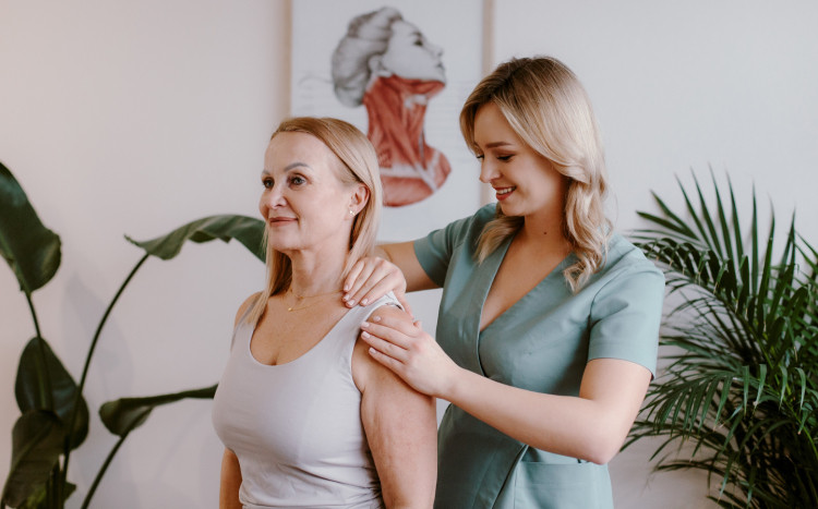 fizjoterapeutka masuje ramię kobiety