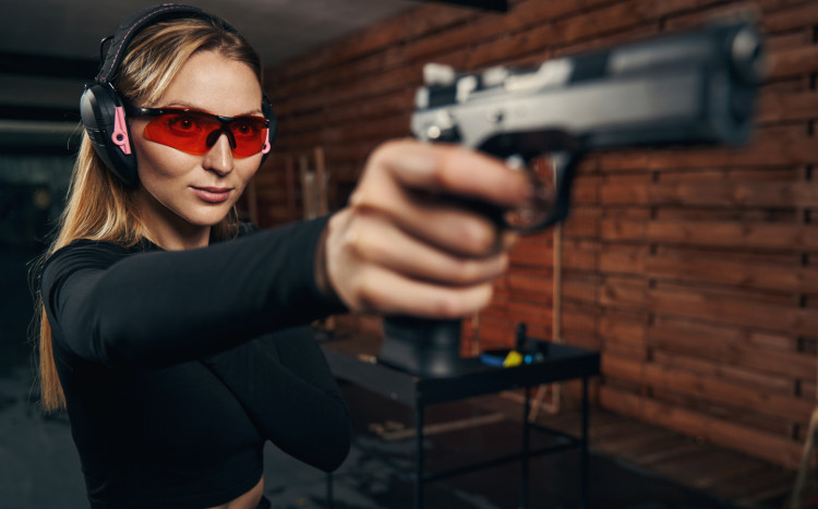 kobieta strzela z broni krótkiej