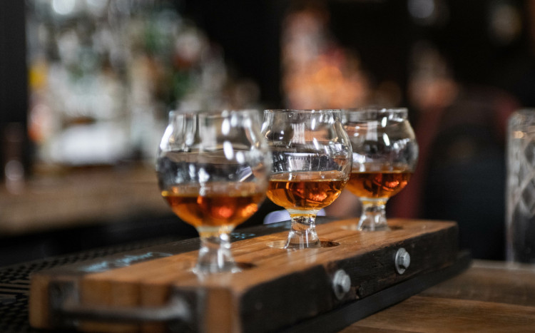 okrągłe szklanki z whisky na drewnianej desce 