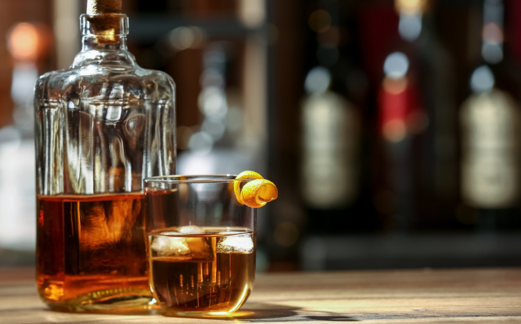 whisky z lodem i cytryną na drewnianym barze