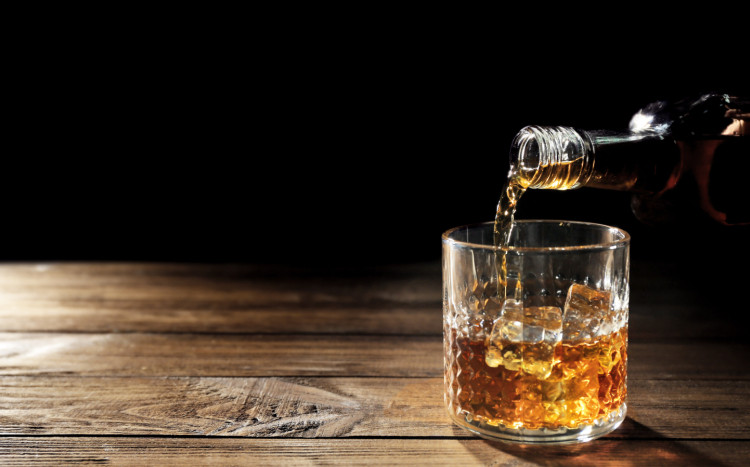 nalewanie whisky do okrągłej szklanki z lodem