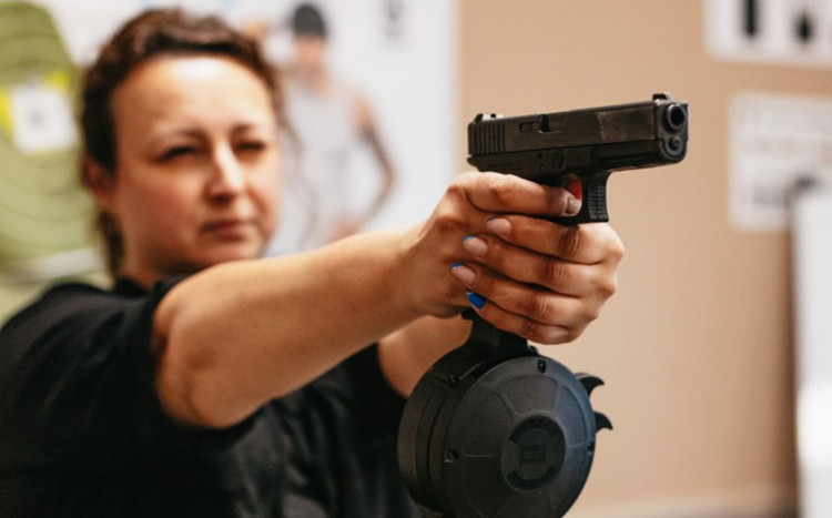 kobieta oddaje strzały z pistoletu