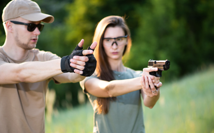 Skupiona kobieta podczas nauki strzelania z broni