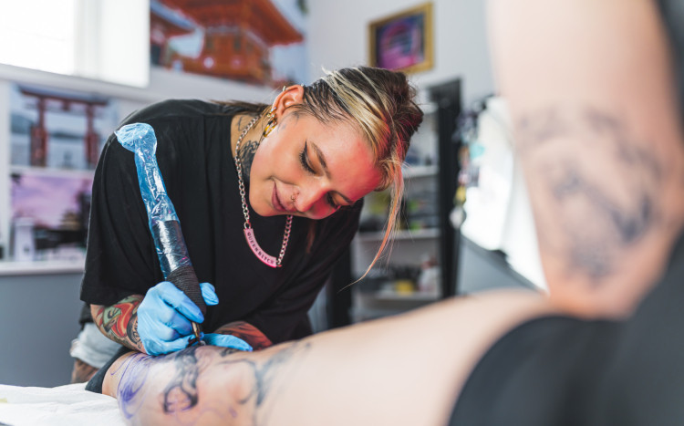 Kobieta wykonująca tatuaż