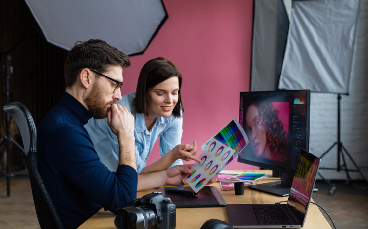 Kobieta i mężczyzna pracujący nad kolorystyką zdjęcia do przeróbki graficznej