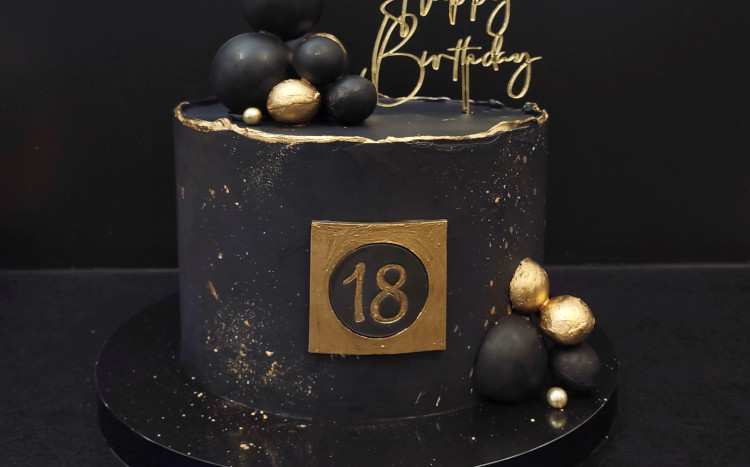 Czarny i elegancki tort z okazji 18. urodzin z napisem Happy Birthday.