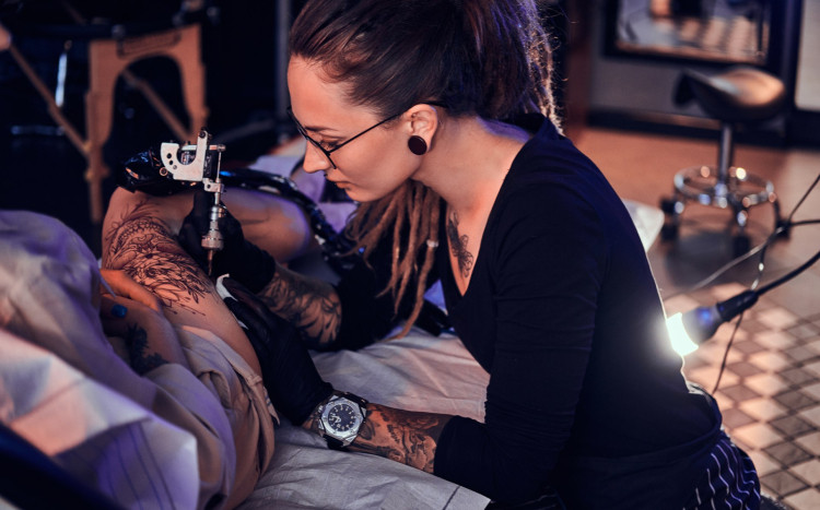 kobieta wykonuje tatuaż
