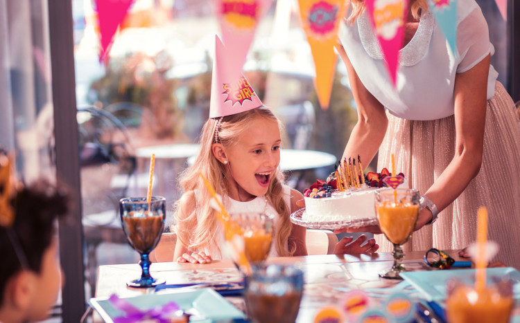 Zadowolona dziewczynka na widok urodzinowego tortu