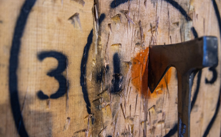 Siekierka wbita w pomarańczowy punkt na drewnie, który oznacza sam środek planszy, czyli cel.