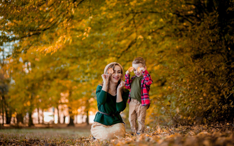 Matka z dzieckiem pod jesiennym drzewem