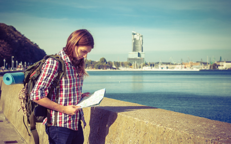 Mężczyzna znajdujący się w Gdyni tuż przy morzu korzysta z mapy, aby znaleźć punkt