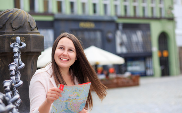 Uśmiechnięta kobieta w mapą w ręku