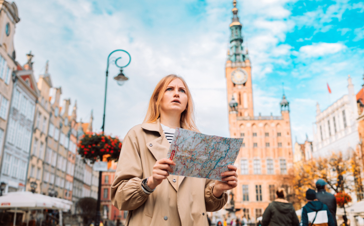 Zaniepokojona kobieta znajdująca się Gdańsku z mapą w ręku