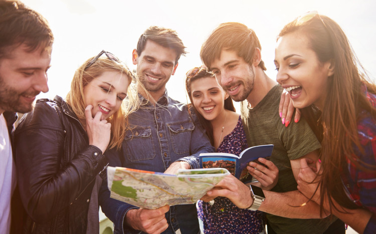 Grupa sześciu osób patrząca z uśmiechem na mapy miasta