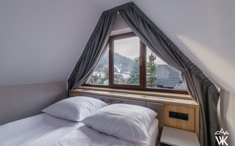 Łóżko i widok z okna na Wielką Krokiew w Zakopanem