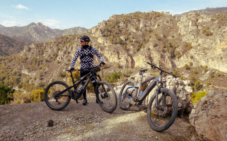 Jeden mężczyzna i dwa rowery elektryczne z widokiem na góry w Andaluzji