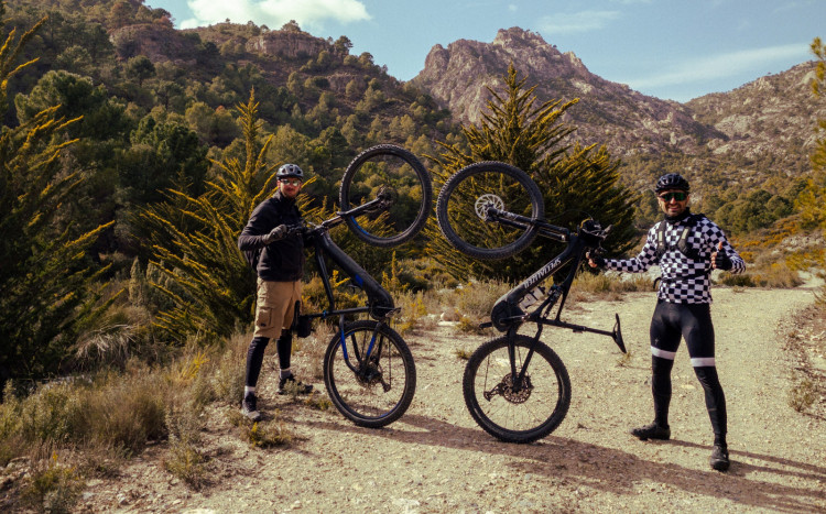 Dwóch mężczyzn w kaskach trzymających rowery elektryczne na jednym kole w Andaluzji