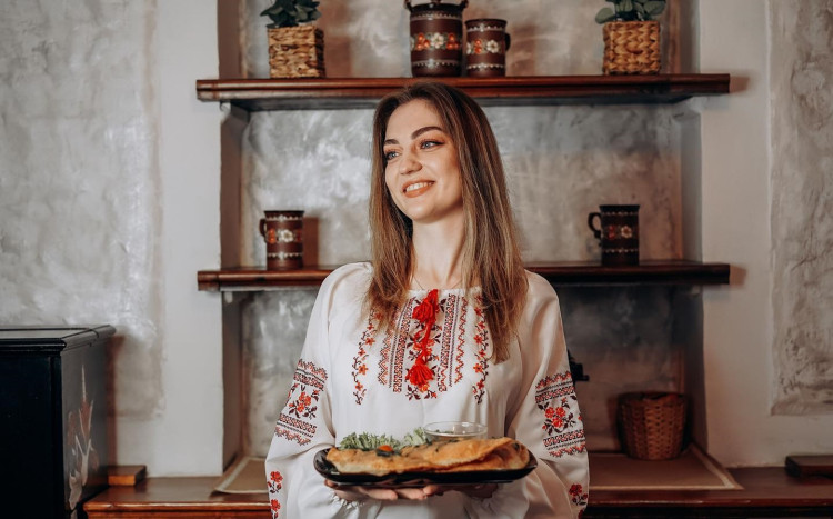 Radosna dziewczyna, która trzyma tradycyjną potrawę kuchni ukraińskiej
