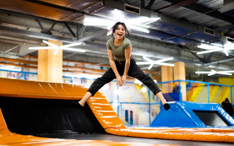 Szczęśliwa kobieta skacząca w górę w parku trampolin