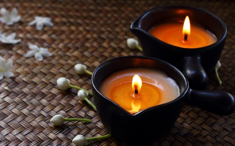 ciepły olejek ze świecy do masażu wylewany na dłoń masażysty