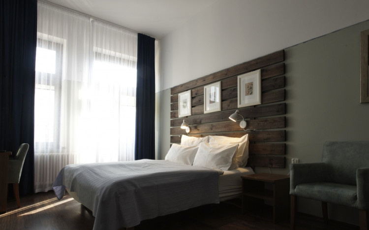 Sypialnia urządzona w dość urokliwym stylu łącząc w sobie stonowane barwy i drewno