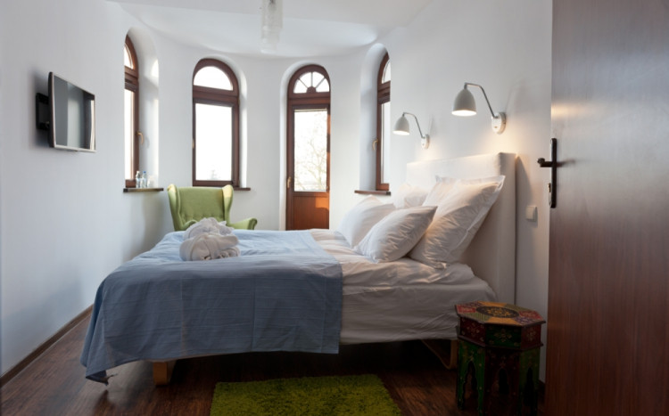 Sypialnia z dużym łóżkiem i zielonymi dodatkami