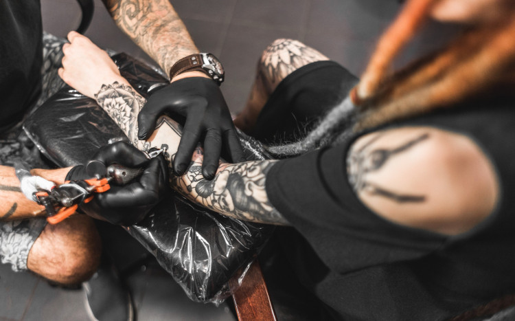 Kobieta, na której ręce tatuowany jest czarny tatuaż na przedramieniu