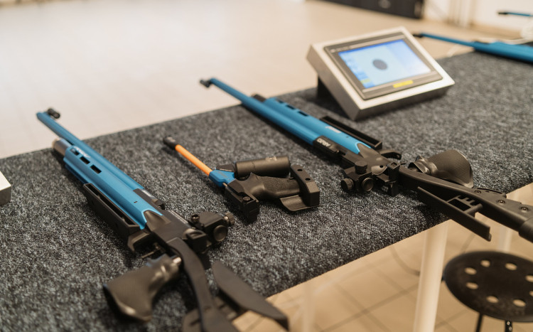 Broń pneumatyczna w kolorze niebieskim, mały monitor i taboret