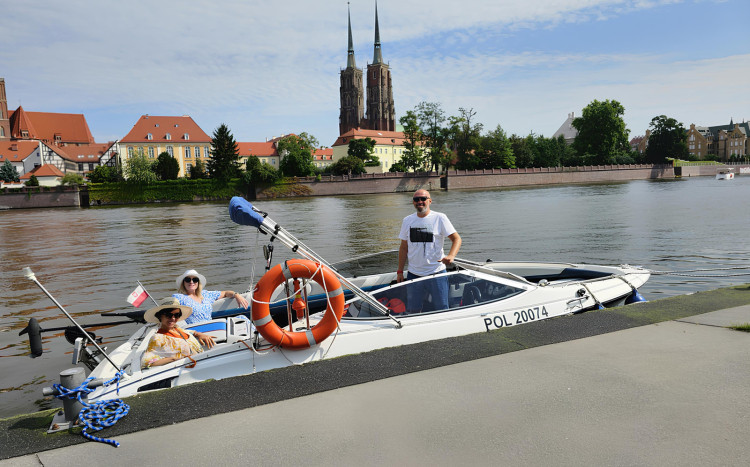 Trzy osoby na łodzi łącznie ze sternikiem podczas rejsy wycieczkowego po Odrzew we Wrocławiu