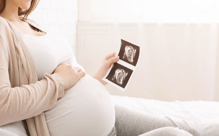 kobieta w ciąży ogląda zdjęcia z usg