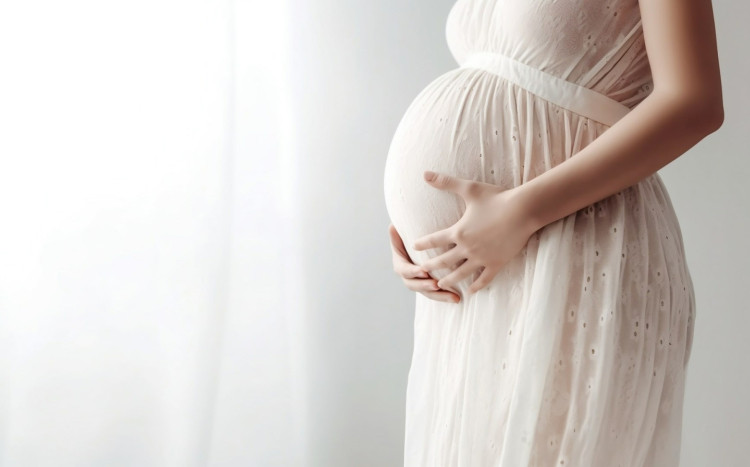 kobieta w ciąży pozuje w sukni