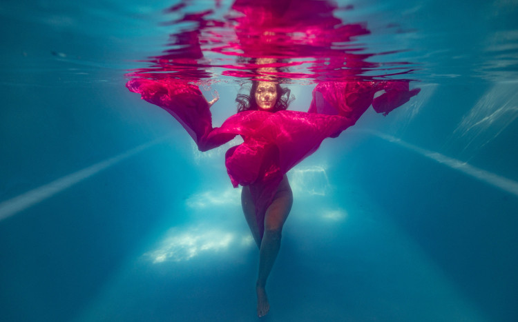 Kobieta w różowym ubraniu pozująca do zdjęcia pod wodą