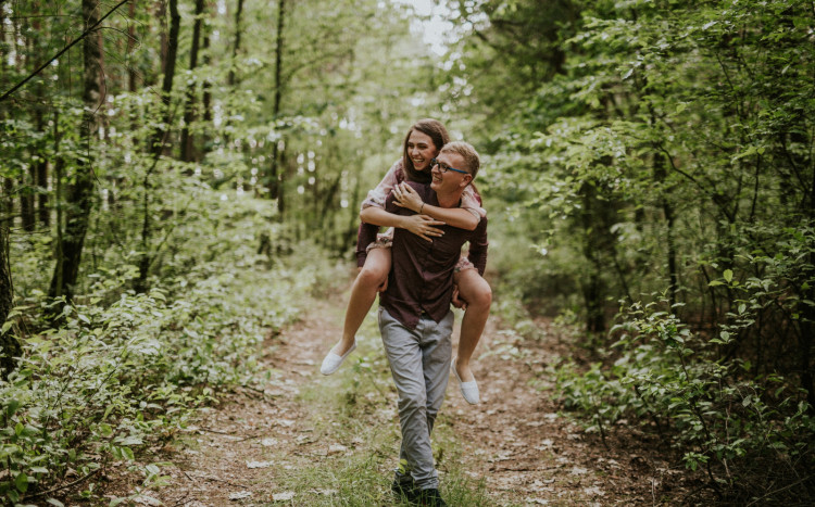 Mężczyzna trzymający dziewczynę na plechach w lesie