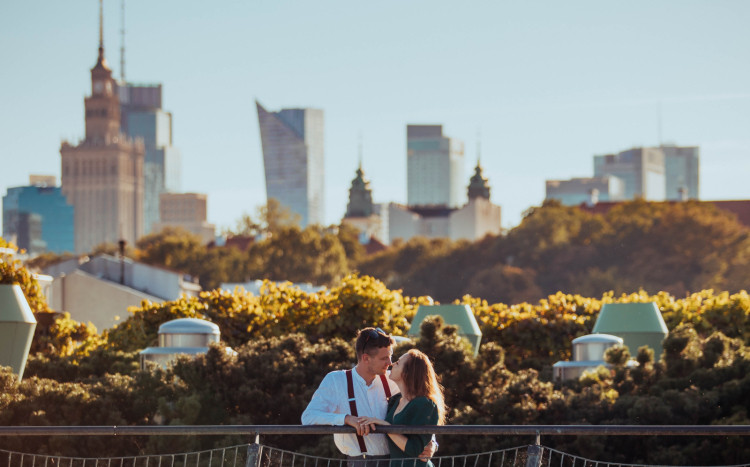 Para całująca się na moście z widokiem na warszawskie wieżowce