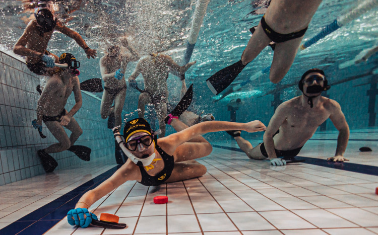 Grupa osób pozująca pod wodą w basenie do zdjęcia