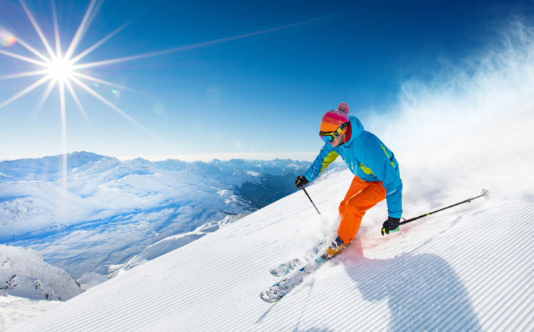 Osoba jadąca na nartach po śniegu na szczytach gór