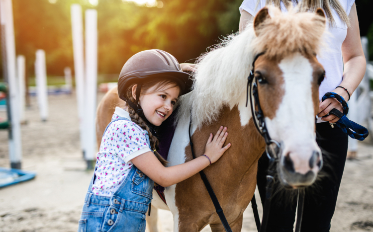dziewczynka przytula się do konia