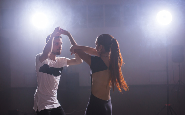 Para osób tańcząca ze sobą podczas nauki tańca na sali