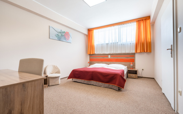Pokój dwuosobowy z biało-pomarańczowymi łóżkami dla gości