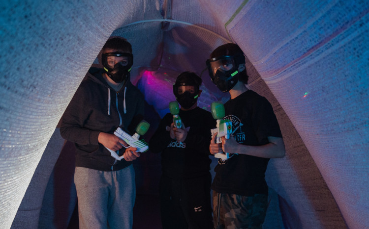 Trzech chłopaków stojących w maskach z pistoletami Gel Blaster
