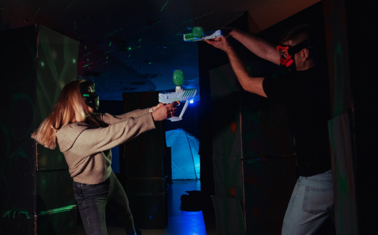 Kobieta i mężczyzna bawiący się w żelowy paintball za pomocą pistoletów Gel Blaster