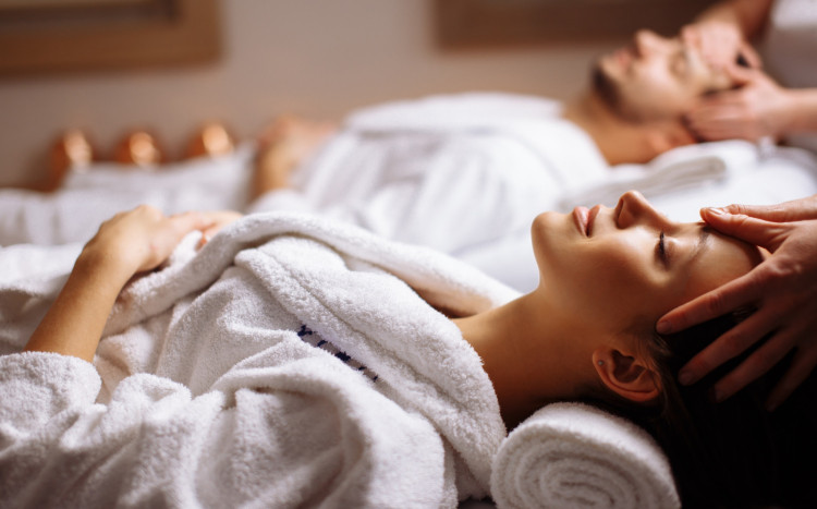 Kobieta i mężczyzna leżący w pełnym odprężeniu na plecach podczas wspólnego masażu