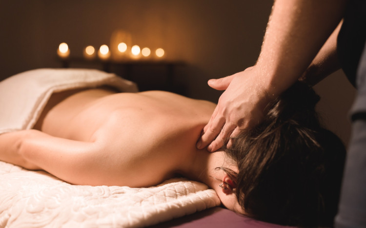 Kobieta leżąca na brzuchu podczas masażu szyi
