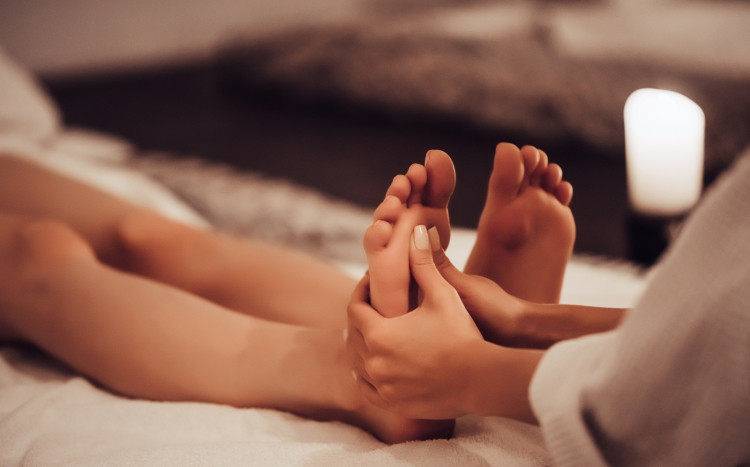 Kobiece dłonie masujące stopy