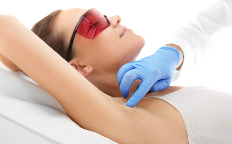 Kobieta w okularach chroniących przed laserem tuż przed epilacją pachy