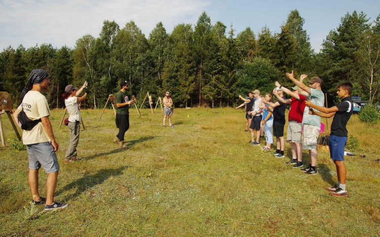 Grupa osób podczas szkolenia z rzucania nożem do celu